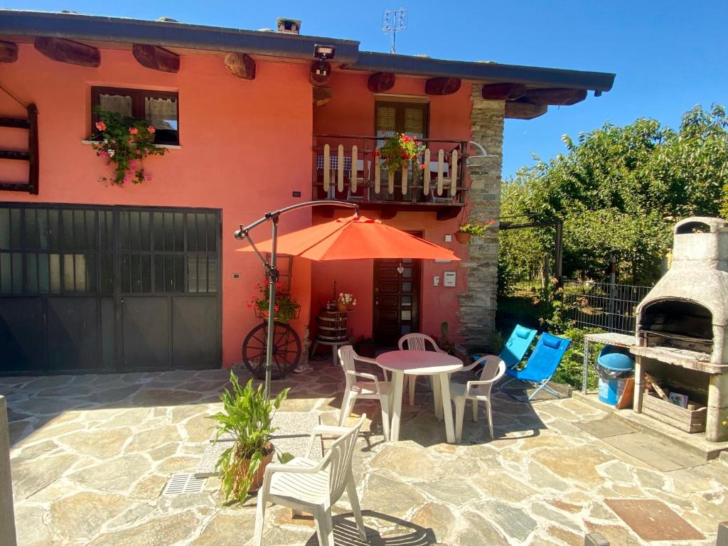 a patio with a table and chairs and an umbrella at Casa "La Fucina" in Melle