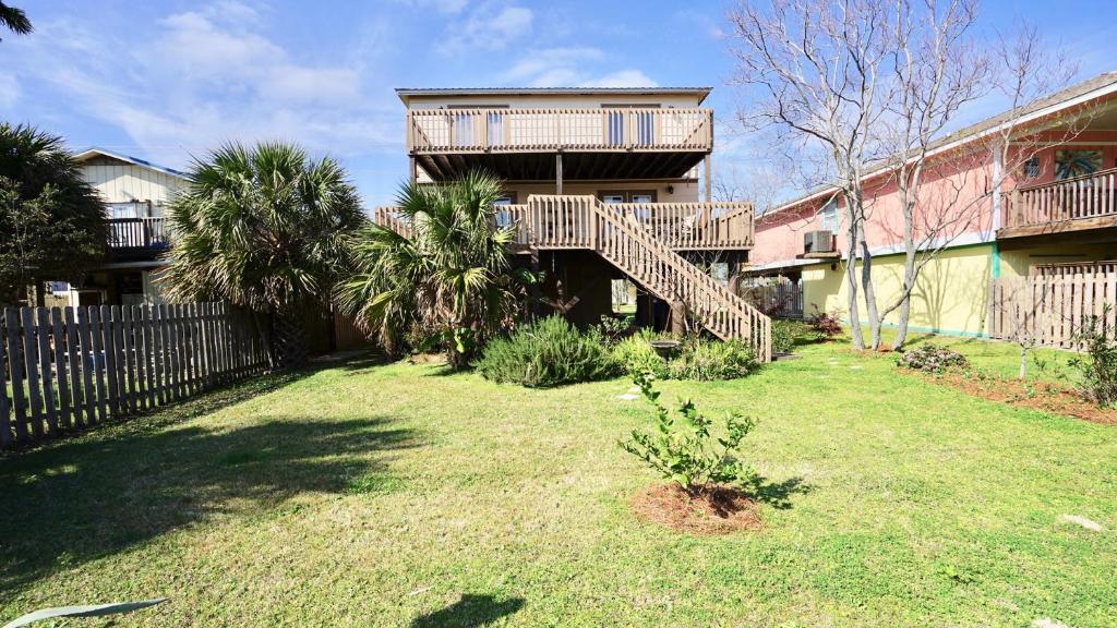 une maison avec un escalier en bois dans une cour dans l'établissement 3 Palms West, à Gulf Shores