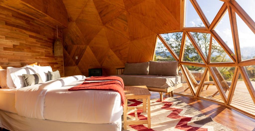 エル・カラファテにあるEstancia Patagonia El Calafate - Pristine Luxury Campsのベッド1台とソファ1台が備わる客室です。