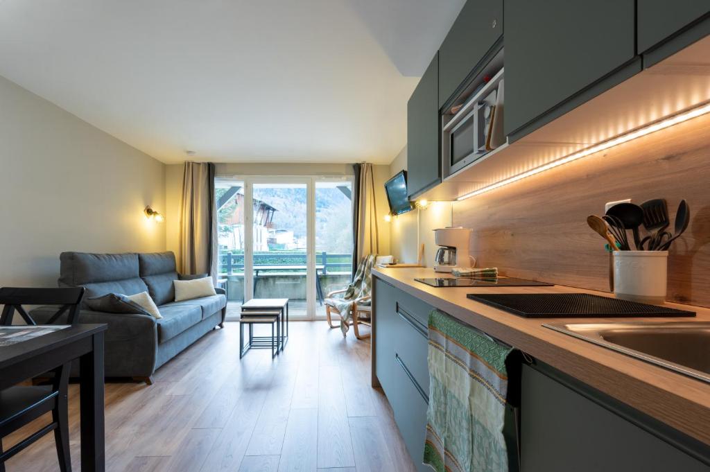 une cuisine et un salon avec un canapé dans l'établissement Appart. 4 couchages 3 étoiles - Accès télécabine, à Saint-Lary-Soulan