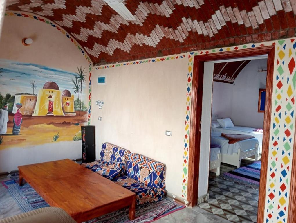 Ramy Heissa Nubian house في أسوان: غرفة معيشة مع أريكة وطاولة