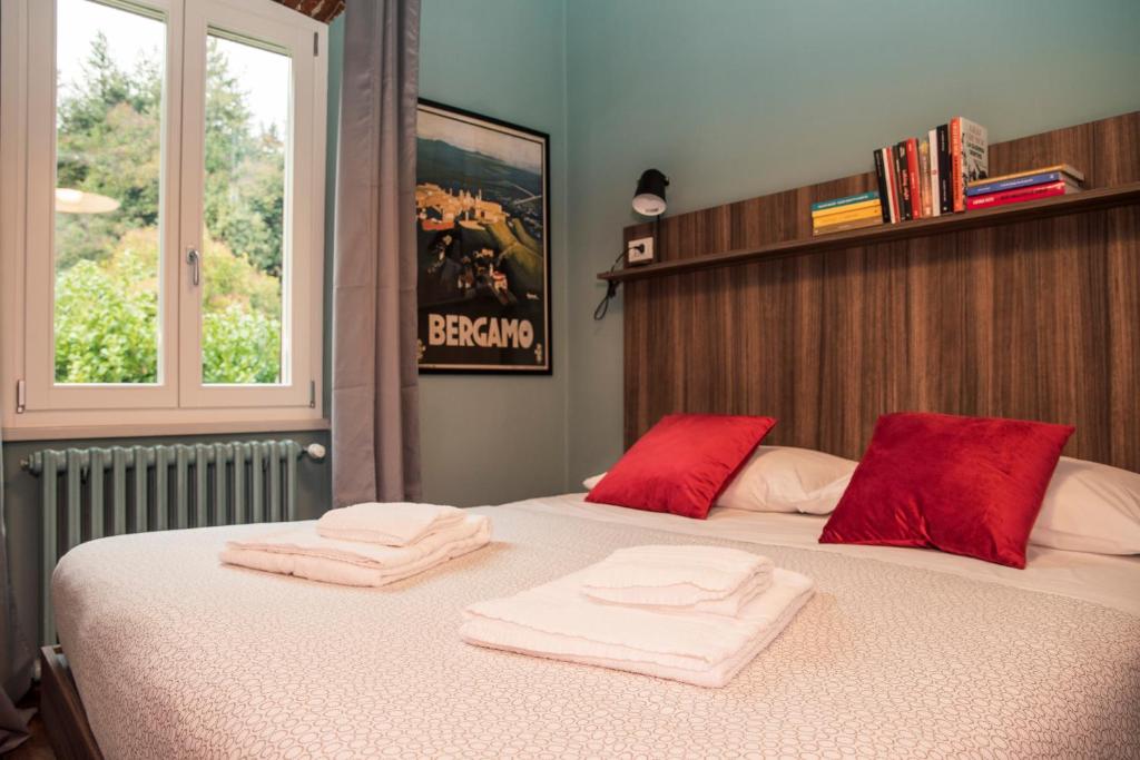 a bedroom with two towels on a bed with a window at AL NIDO LEGAMI charme e relax in Bergamo