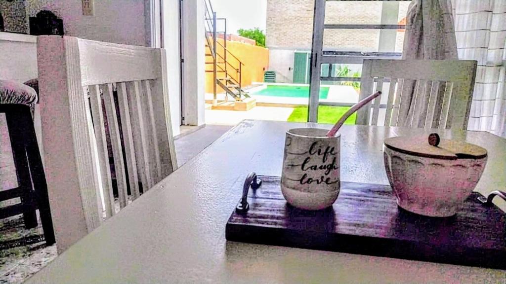 - une table avec un bol et une tasse sur le balcon dans l'établissement Arizona, à Chascomús