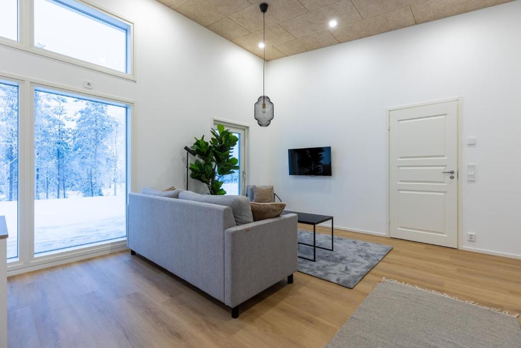 un salon avec un canapé et une grande fenêtre dans l'établissement Villa Morning Star, à Rovaniemi