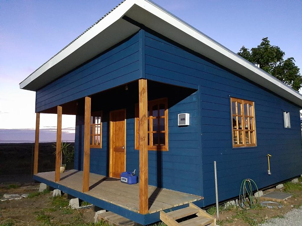 a blue tiny house with a porch at Cabañas de Campo MARBAJA in Puerto Montt