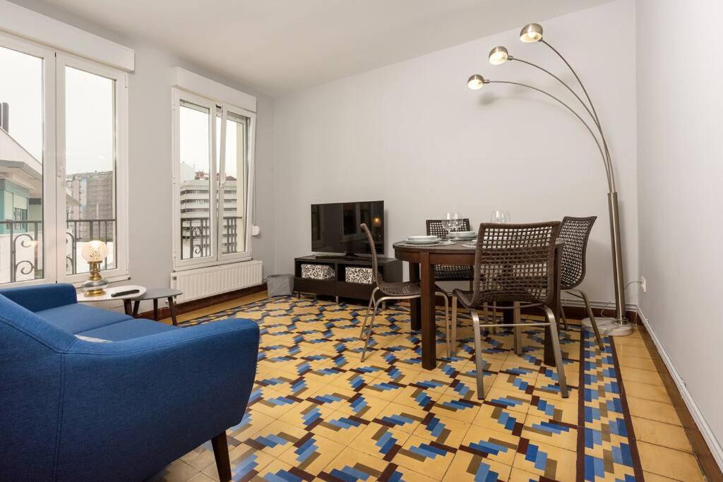 uma sala de estar com mesa e cadeiras em MyHouseSpain - Céntrico y luminoso piso em Gijón