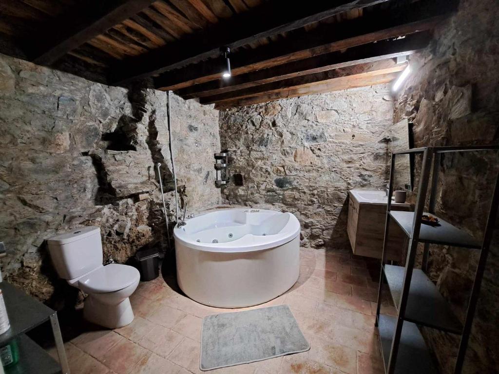 La salle de bains en pierre est pourvue d'une baignoire et de toilettes. dans l'établissement PITHARIA, à Askas