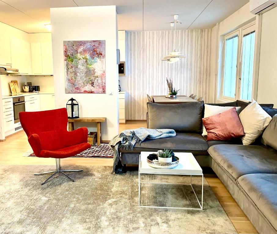 sala de estar con sofá y silla roja en Modern and cosy 3-bedroom apartment with private sauna, in trendy Kalasatama, en Helsinki
