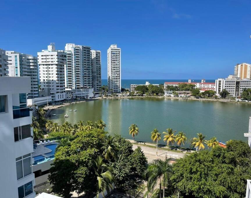 a large body of water with palm trees and buildings at Apartamento laguito vista al mar in Cartagena de Indias