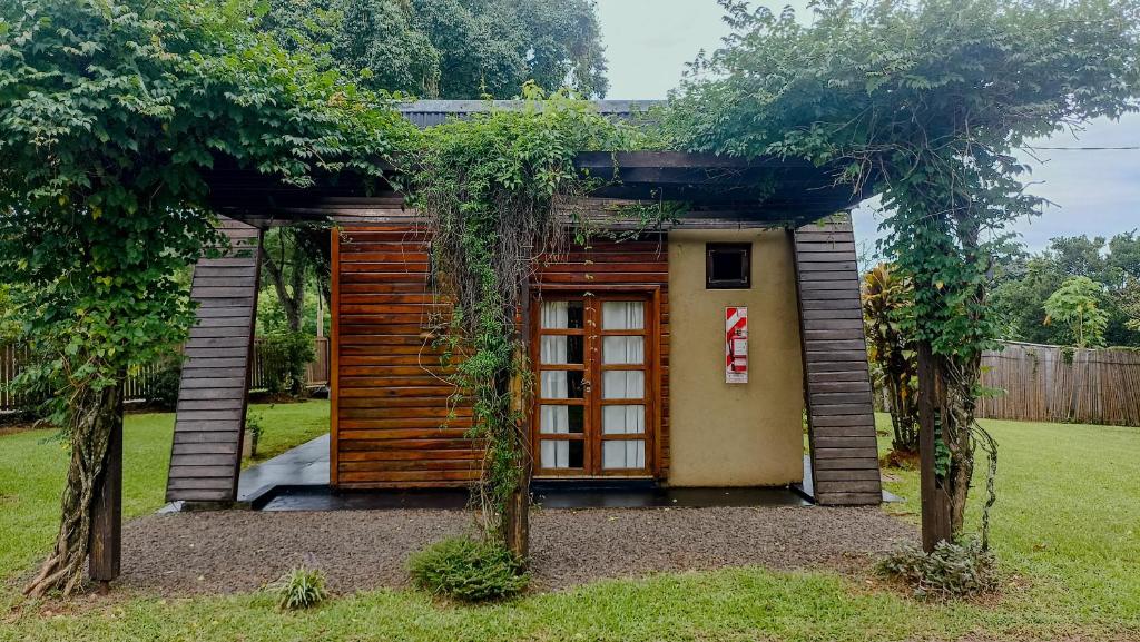 ein kleines Haus mit einer Tür im Hof in der Unterkunft Cabañas Brizas del Norte in San Ignacio