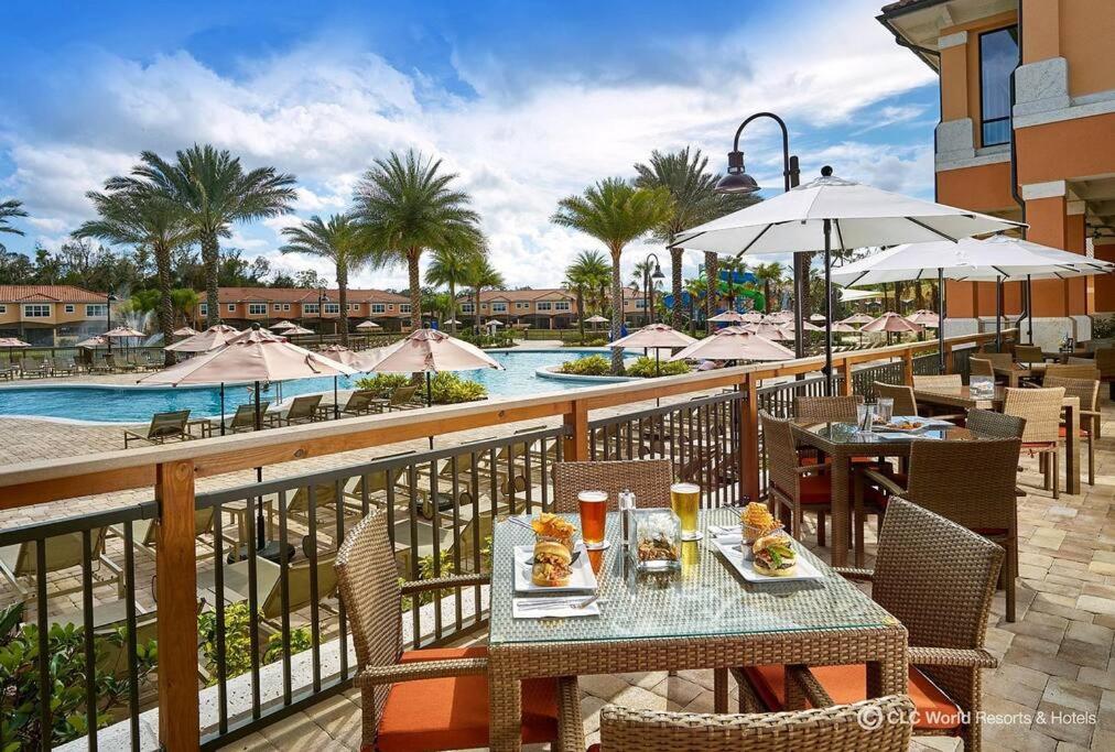 un balcón con mesas y sillas y una piscina en Charming 4br/3.5bth Family Haven (15 Minutes to Disney), en Orlando