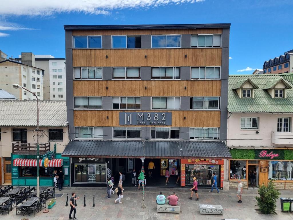 a large building with people walking in front of it at M382 Hotel Bariloche in San Carlos de Bariloche