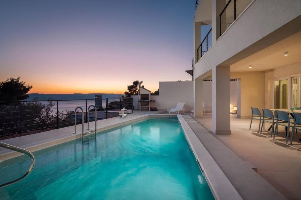 una piscina en medio de una casa en Modern Villa Maris - with heated pool & sea view, en Brela