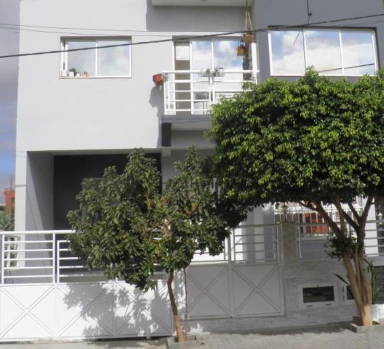 a white building with two trees in front of it at Residencia BB in Praia