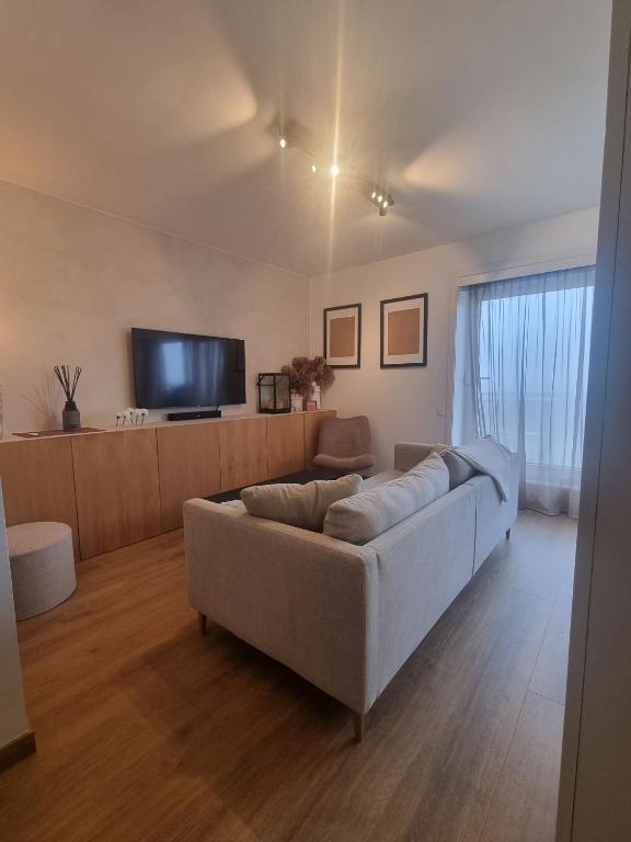 a living room with a couch and a flat screen tv at Beautiful Bruges in Zeebrugge