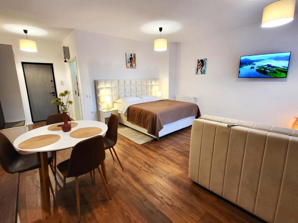 a bedroom with a bed and a table and a couch at Garden City Studio in Sibiu