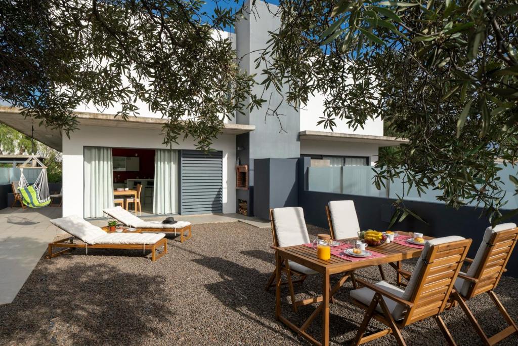 a patio with a table and chairs and a house at Villa Girassol by An Island Apart in Porto Santo