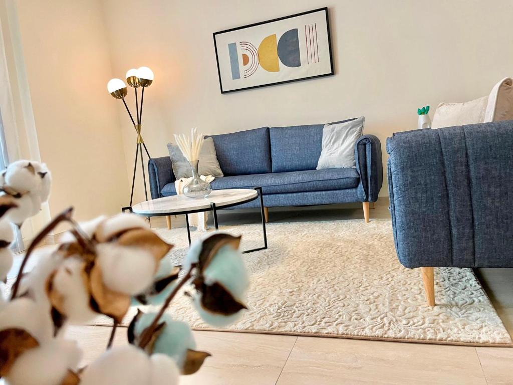 a living room with a blue couch and a table at Elite LUX Holiday Homes - Two Bedroom Apartment Direct Metro Access in Al Furjan, Dubai in Dubai