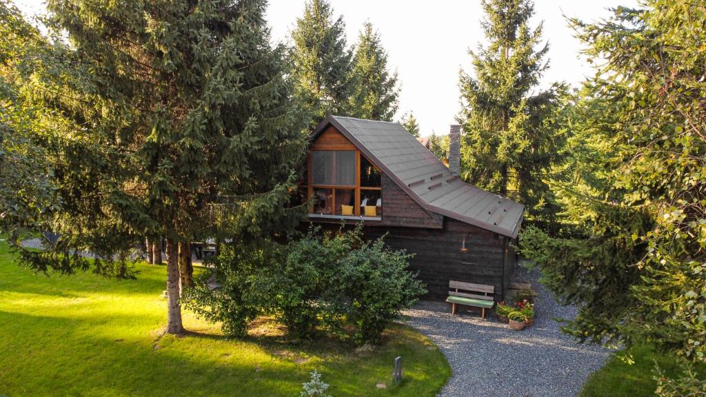 Cabaña de madera pequeña con ventana y banco en La Brazi - by 663A Mountain Chalet en Porumbacu de Sus