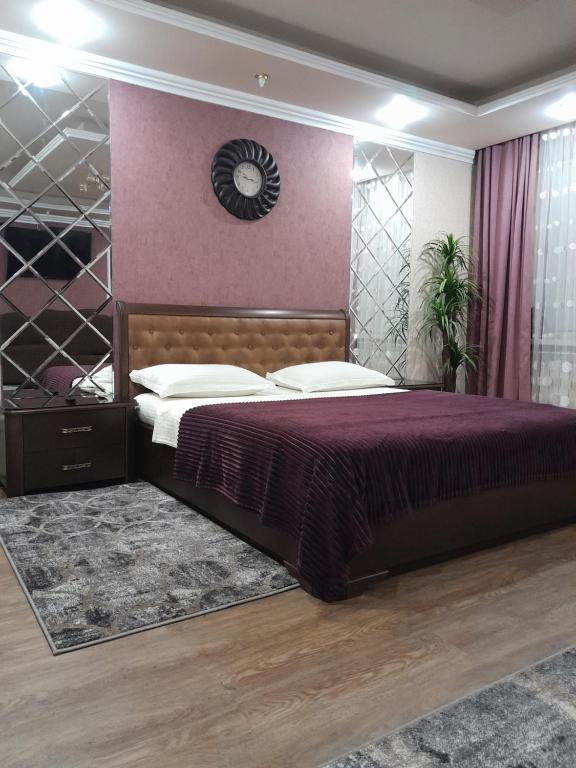 ein Schlafzimmer mit einem Bett und einer Uhr an der Wand in der Unterkunft Apartment in a New House in Krementschuk