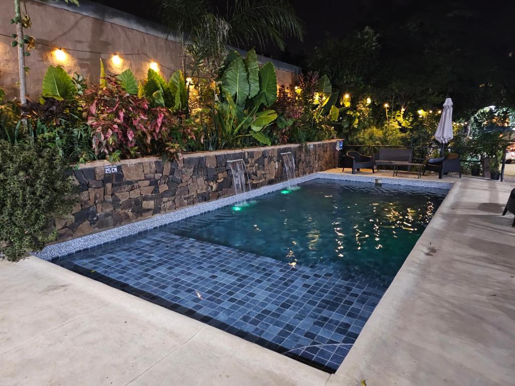 a swimming pool in a backyard at night at Charaí Lodge in Puerto Iguazú