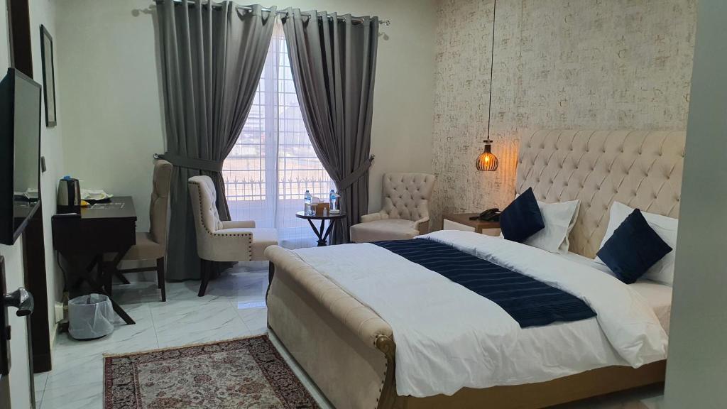 a bedroom with a large bed and a window at Bloom Rooms in Islamabad