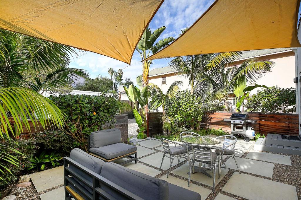 a patio with a table and chairs and an umbrella at West Beach Villa 3 in Santa Barbara