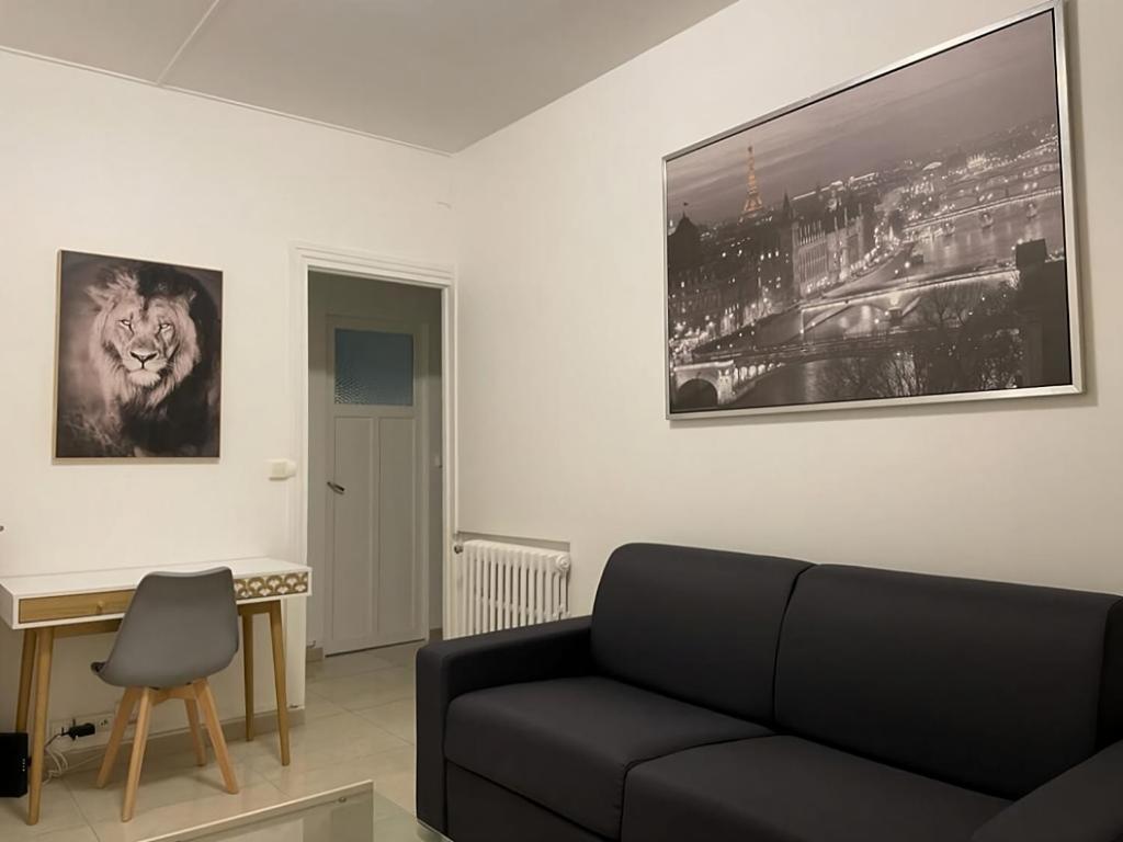a living room with a black couch and a desk at Charmant studio Paris expositions porte de Versailles - Dôme de Paris - JO Olympic Games 2024 Paris South Arena 1-4-6 in Vanves