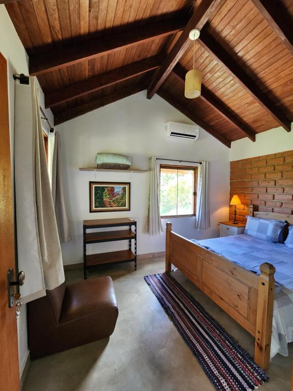 a bedroom with a bed and a wooden ceiling at Refúgio Tao Cerrado Chalé Pé de Serra in Alto Paraíso de Goiás