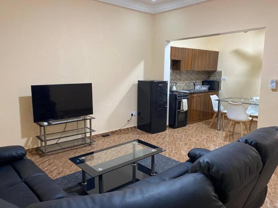 salon z kanapą i telewizorem w obiekcie Saffy Guest House w mieście Brikama
