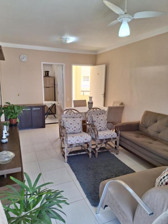 uma sala de estar com um sofá, uma mesa e cadeiras em Lindo apto 3 qtos, a 350 mtrs praia da enseada com serviço de praia e portaria 24 hrs próx casa grande hotel, hipermercados, farmácias bancos no Guarujá