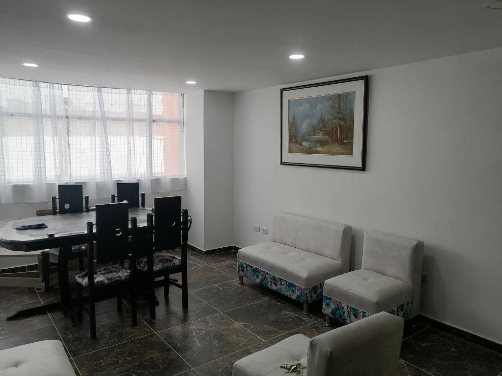 ein Wohnzimmer mit einem Tisch und einem Esszimmer in der Unterkunft APARTAMENTO AMOBLADO BARRIO LAS VIOLETAS in Pasto