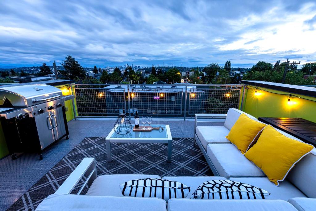a patio with couches and a table and a grill at 47th Elegance BY Betterstay in Seattle