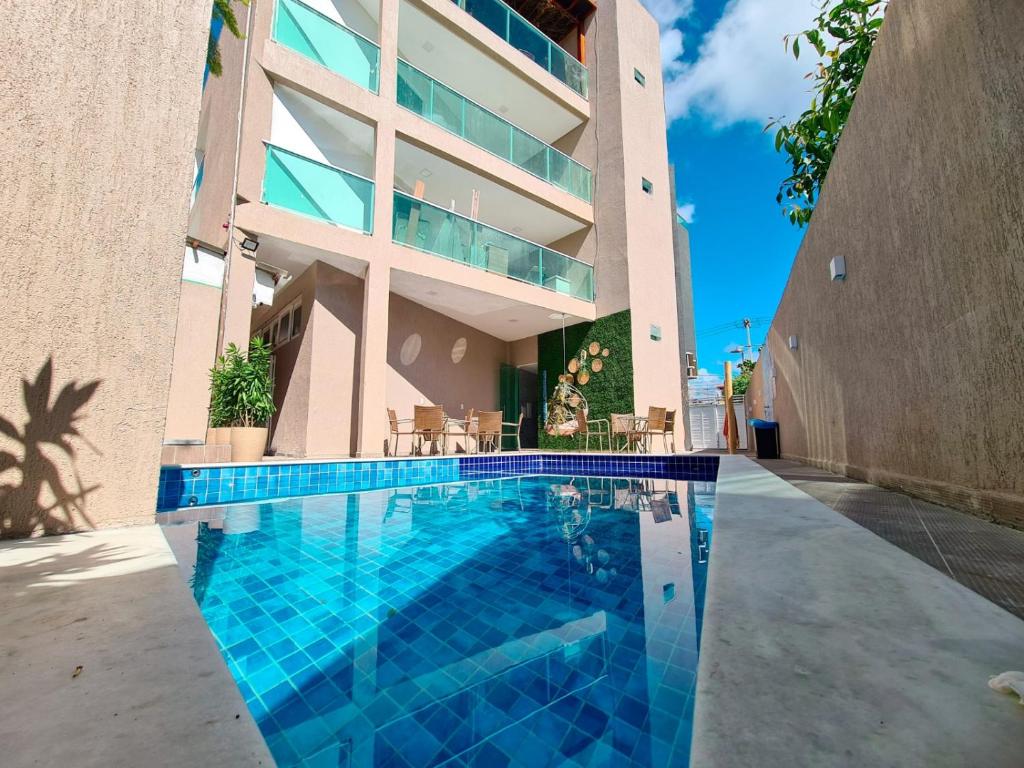 a swimming pool in front of a building at Sunset by AFT - PORTO DE GALINHAS in Porto De Galinhas