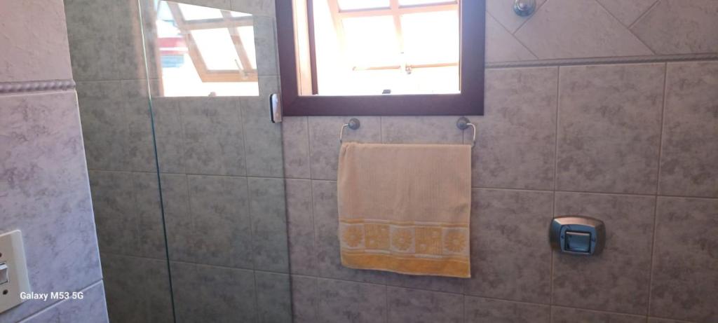 een douche met een handdoek en een raam in de badkamer bij Duplex na Praia dos Ingleses in Florianópolis
