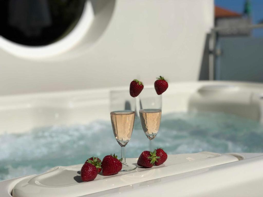 due bicchieri di champagne e fragole su un piatto di un aereo di Luxus Ferienhaus - Kleine Rosenvilla a Sassnitz