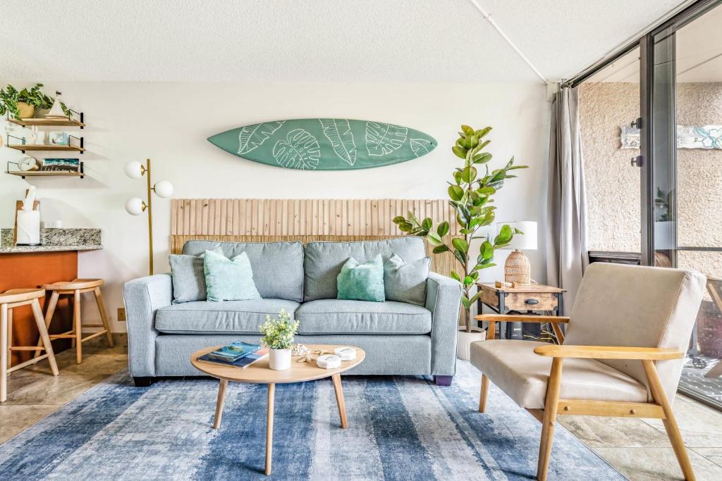 uma sala de estar com um sofá azul e uma mesa em Maui Vista 3114 BY Betterstay em Kihei