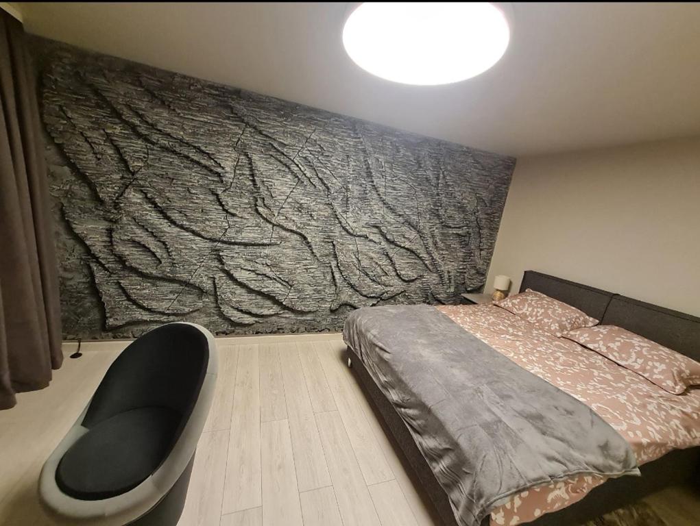 a bedroom with a bed and a wall with a tree mural at ALISE in Ludza