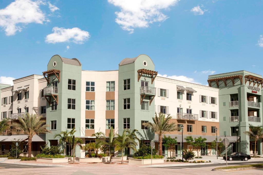 ein großes Gebäude mit Palmen davor in der Unterkunft Courtyard by Marriott Palm Beach Jupiter in Jupiter
