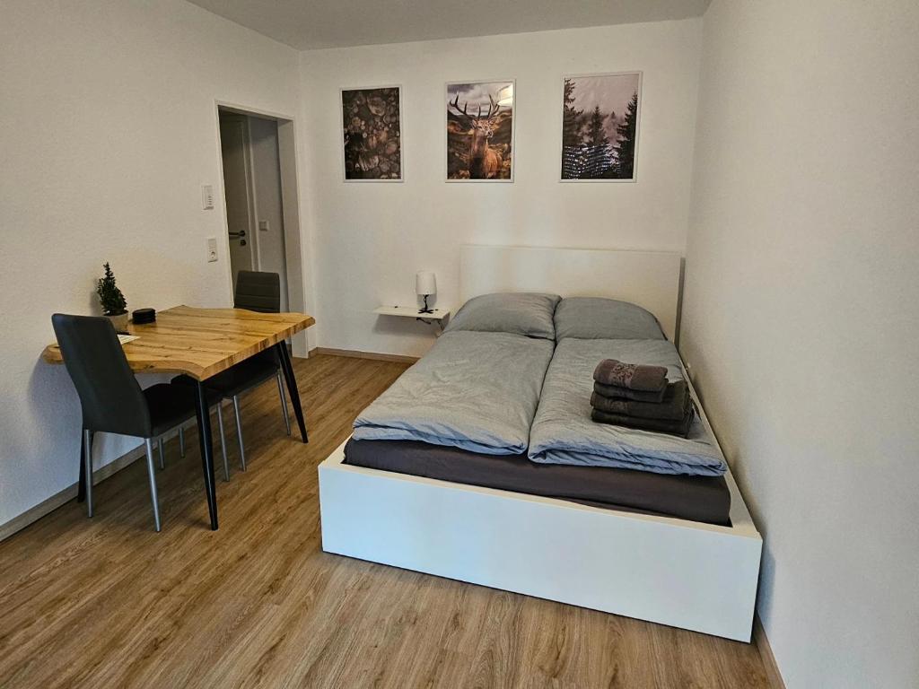 Schlafzimmer mit einem Bett und einem Holztisch in der Unterkunft Fewo am premium Wanderort in Bad Berleburg