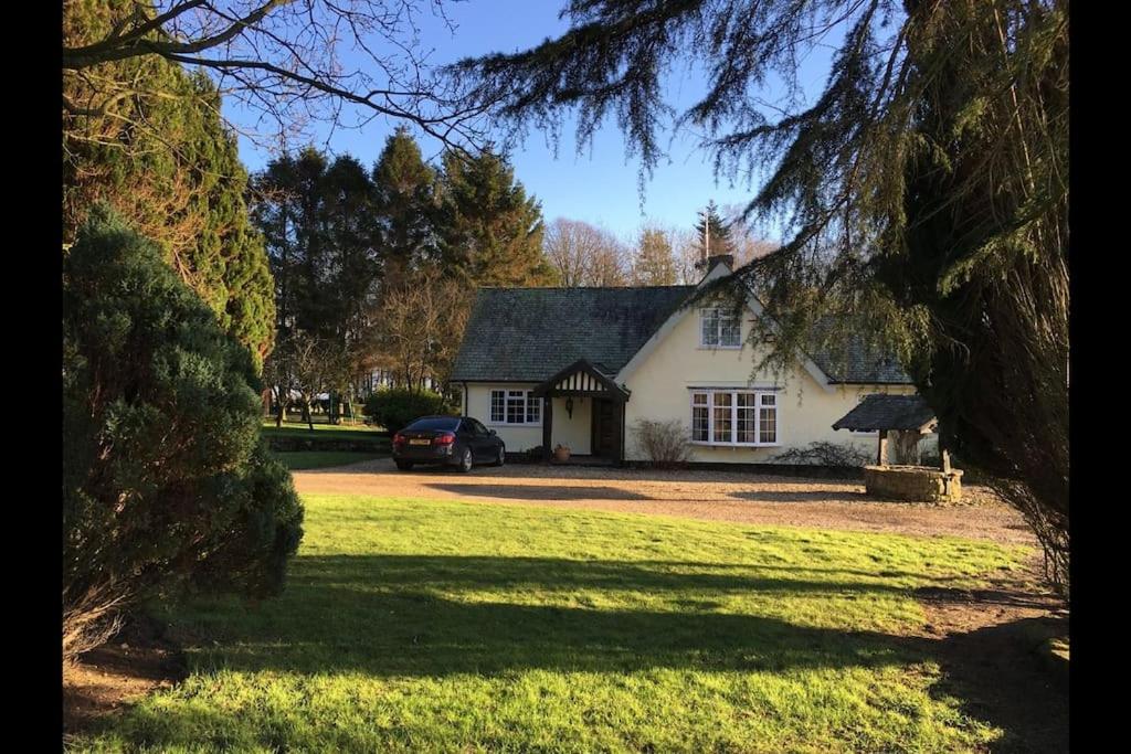 una casa blanca con un coche aparcado delante de ella en Brownhills, en Eaton