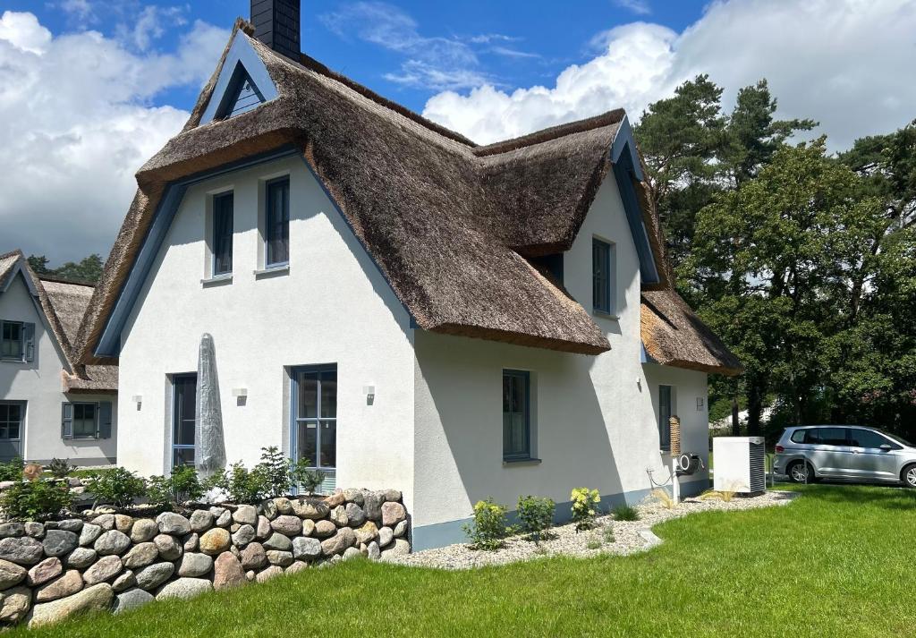 a white house with a thatched roof at Ferienhaus Fischerhuus in Zirchow