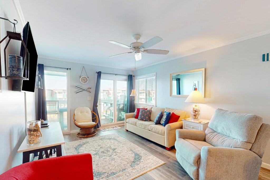 - un salon avec un canapé et un ventilateur de plafond dans l'établissement Seaspray 320, à Atlantic Beach
