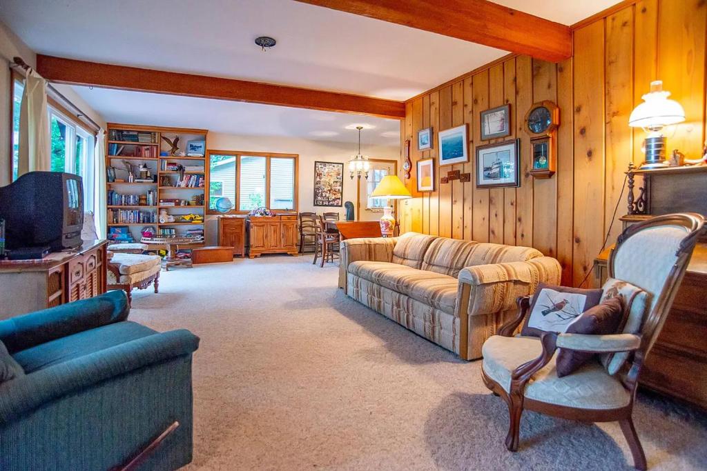 sala de estar con sofá y TV en Smith Family Cottages- Lake House, en Indian River