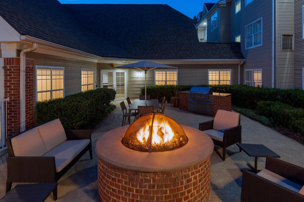 un patio con una hoguera con sillas y una mesa en Residence Inn Greenville-Spartanburg Airport, en Greenville