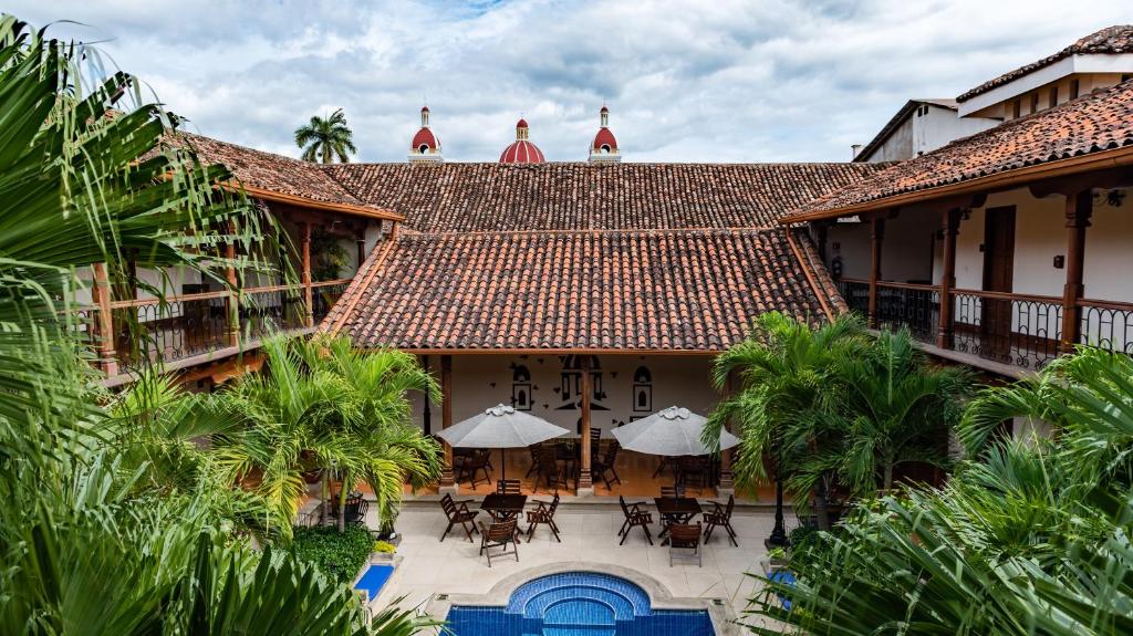 une vue aérienne sur un bâtiment avec des tables et des parasols dans l'établissement Hotel Plaza Colon - Granada Nicaragua, à Granada