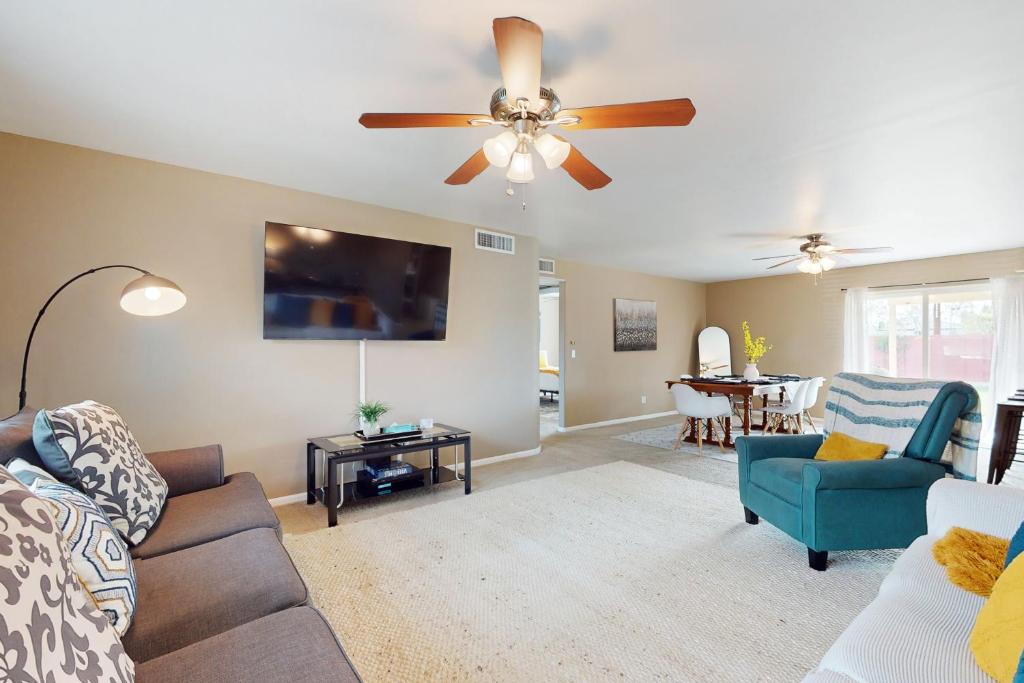 a living room with a couch and a ceiling fan at Time for Tempe in Tempe