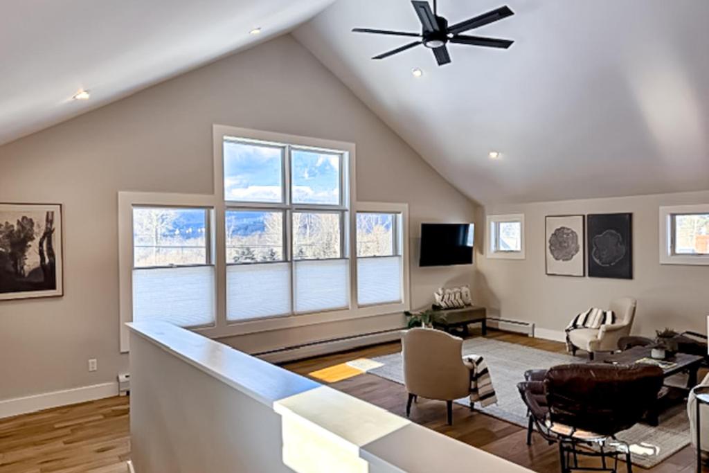 uma sala de estar com um tecto abobadado com janelas em Mountain View em Stowe