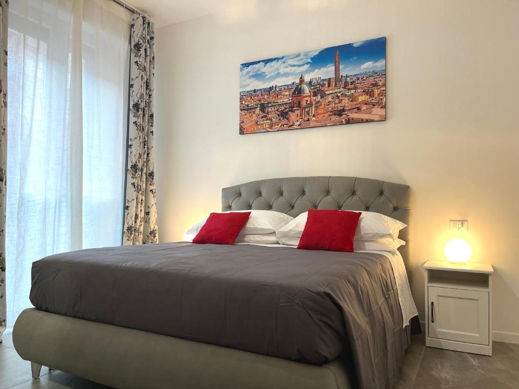 una camera da letto con un grande letto con cuscini rossi di Bologna Homes a Bologna