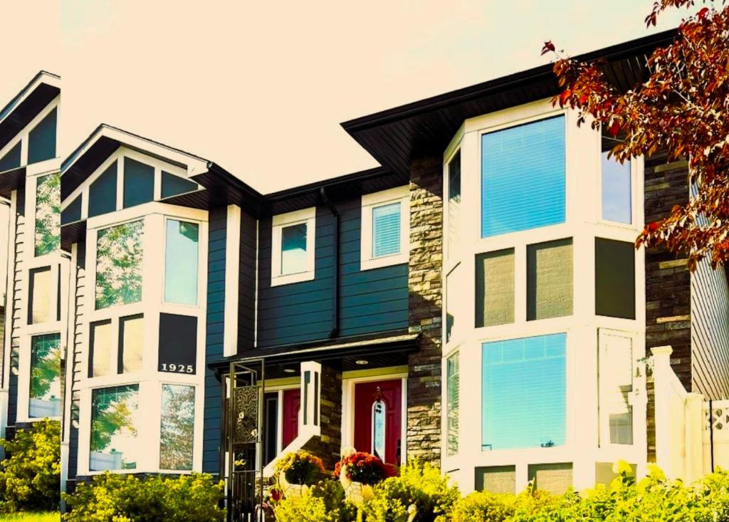 une maison avec des fenêtres bleues et blanches dans l'établissement Lovely comfy home private bath in central Calgary, à Calgary